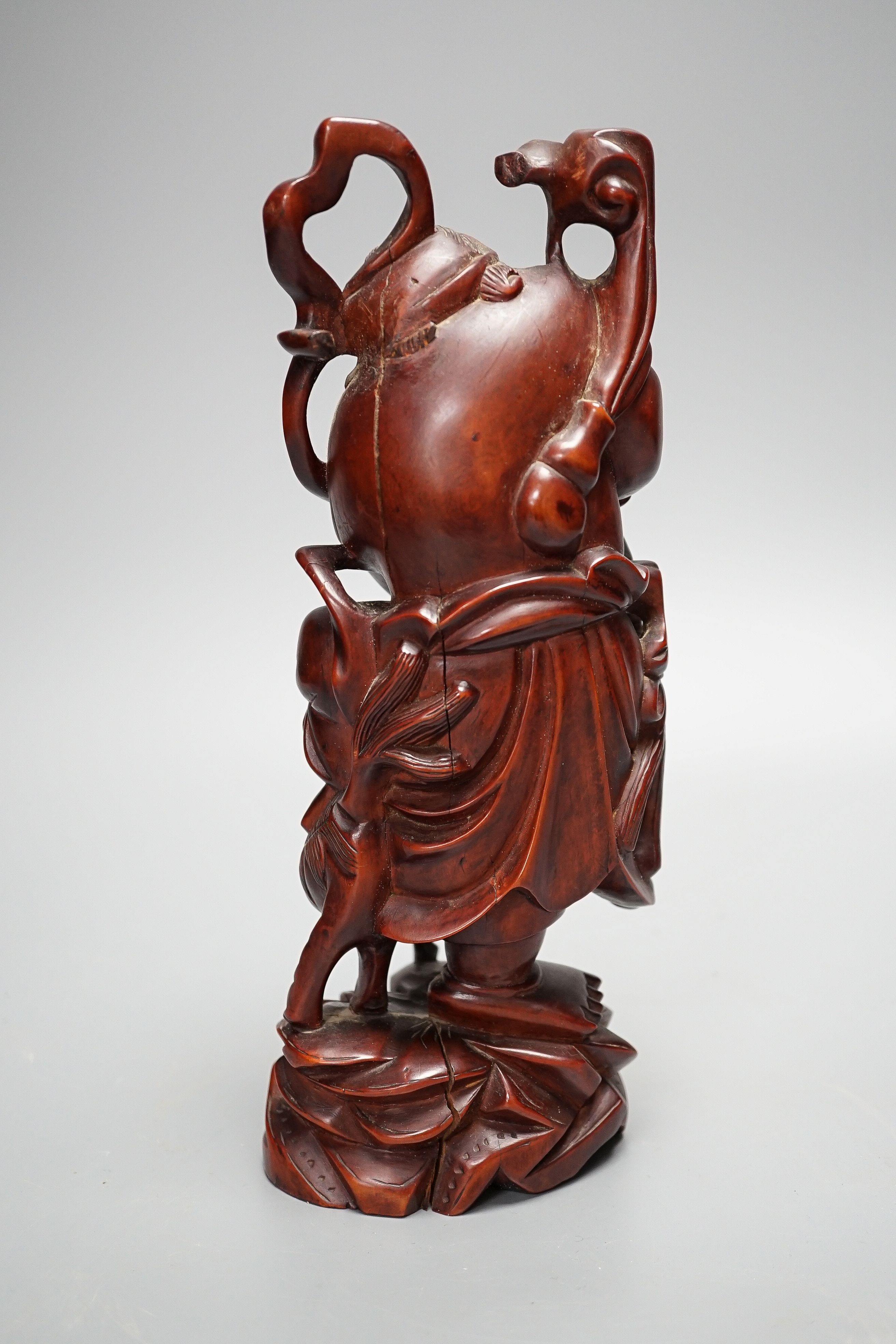 A Chinese carved cherrywood group of an immortal and a beast, early 20th century, height 24cm